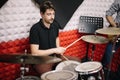 Portrait of male drummer playing on drum set in studio Royalty Free Stock Photo