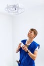 Portrait Of A Male Electrician instaling Lamp