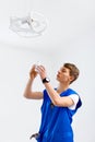 Portrait Of A Male Electrician instaling Lamp