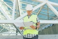 Portrait of male engineer at construction site, builder looks at blueprint. Building, development, teamwork and people concept