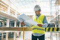 Portrait of male engineer at construction site. Builder looks at the plan of the construction site. Building, development, teamwor Royalty Free Stock Photo