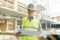 Portrait of male engineer at construction site. Builder looks at the plan of the construction site. Building, development, teamwor Royalty Free Stock Photo