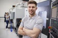 Portrait Of Male Engineer Operating CNC Machinery In Factory