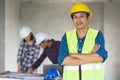 Portrait male engineer wearing safety helmet and holding blueprint in construction site Royalty Free Stock Photo