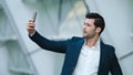 Portrait male entrepreneur taking selfie photo on mobile phone at city street Royalty Free Stock Photo