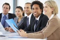 Portrait Of Male Executive Attending Office Meeting With Colleagues