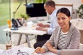 Portrait Of Male And Female Architects Working In Office At Desks On Plans For New Building Royalty Free Stock Photo