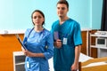 Portrait of male and female doctor in uniform with phonendoscope on her neck holding clipboards Royalty Free Stock Photo