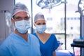 Portrait of male and female nurse wearing surgical mask in operation theater Royalty Free Stock Photo