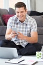 Portrait Of Male Freelance Worker Using Mobile Phone At Home Royalty Free Stock Photo
