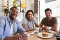 Portrait Of Male Friends Meeting For Lunch In Coffee Shop Royalty Free Stock Photo