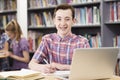 Portrait Of Male High School Student Working At Laptop In Library Royalty Free Stock Photo