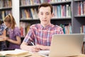 Portrait Of Male High School Student Working At Laptop In Library Royalty Free Stock Photo