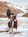 Portrait of a male hunter on horseback with a hunting golden eagle. Eagle hunters are individuals who train and hunt with golden