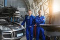 Portrait of male mechanics near car in service center Royalty Free Stock Photo