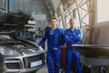 Portrait of male mechanics near car in service center Royalty Free Stock Photo