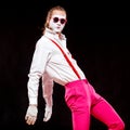 Portrait of male mime artist, isolated on black background. Man in suspenders and pink trousers is posing with his hands Royalty Free Stock Photo