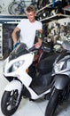 Portrait of male motorcyclist looking on the bike in the store