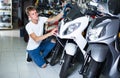 Portrait of male motorcyclist looking on the bike in the store