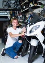 Portrait of male motorcyclist looking on the bike in the store