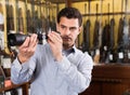Male owner of hunting shop checking optical sights