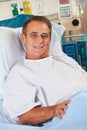 Portrait Of Male Patient Relaxing In Hospital Bed