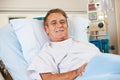 Portrait Of Male Patient Relaxing In Hospital Bed