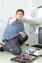 Portrait of male plumber fixing a sink in bathroom Royalty Free Stock Photo