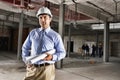 Portrait of a male site manager with blueprint at site Royalty Free Stock Photo