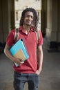 Portrait Of Male Student Carrying Files Outside University Building In Oxford UK