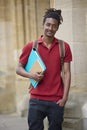 Portrait Of Male Student Carrying Files Outside University Building In Oxford UK