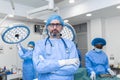 Portrait of male surgeon in operation theater looking at camera. Doctor in scrubs and medical mask in modern hospital operating Royalty Free Stock Photo