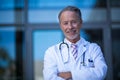 Portrait of male surgeon standing with arms crossed