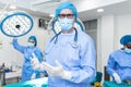 Portrait of male surgeon wearing surgical mask in operation theater at hospital. Healthcare workers in the Coronavirus Covid19 Royalty Free Stock Photo