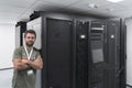 Portrait of male technician or network administrator standing brave as a hero with arms crossed in data center server
