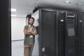 Portrait of male technician or network administrator standing brave as a hero with arms crossed in data center server