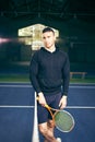 Portrait of a male tennis player. young guy near the net on the court holding a racket in his hands Royalty Free Stock Photo