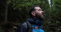 Portrait of a male tourist who stands under the pouring rain