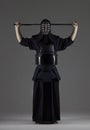 Portrait of male in tradition kendo armor putting his helmet and preparing for the fight
