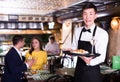 Portrait of male waiter who is holding tray with order Royalty Free Stock Photo
