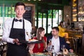 Portrait of male waiter who is holding tray with order Royalty Free Stock Photo