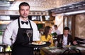 Portrait of male waiter who is holding tray with order Royalty Free Stock Photo