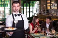 Portrait of male waiter who is holding tray with order Royalty Free Stock Photo