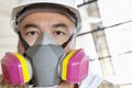 Portrait of male worker wearing dust mask at construction site