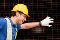 Portrait of a male worker wearing a safety vest and helmet sitting on a steels pallet due to back pain from working Royalty Free Stock Photo