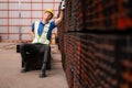 Portrait of a male worker wearing a safety vest and helmet sitting on a steels pallet due to back pain Royalty Free Stock Photo