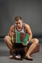 Portrait of a man with accordion sitting on retro suitcase Royalty Free Stock Photo
