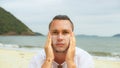 Portrait man apply sun cream protection lotion.Man looking at camera, relax on beach near sea smearing sunscreen cream Royalty Free Stock Photo