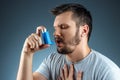 Portrait of a man with an asthma inhaler in his hands, an asthmatic attack. The concept of treatment of bronchial asthma, cough,