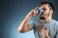 Portrait of a man with an asthma inhaler in his hands, an asthmatic attack. The concept of treatment of bronchial asthma, cough, Royalty Free Stock Photo